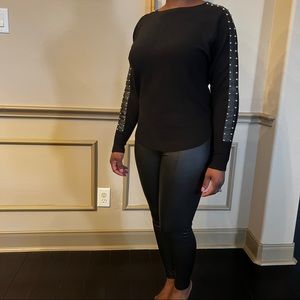 Stylish black sweater with faux leather and stud details